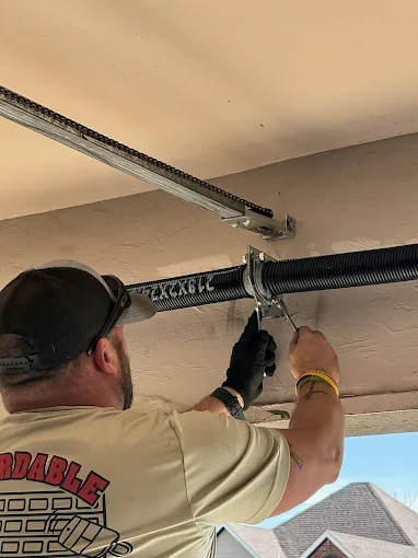 Affordable Door Co technician repairing garage door spring in Oklahoma City OK
