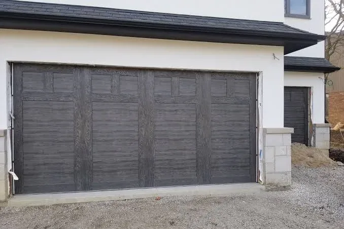 Wood-grain textured garage door on modern home installed by Affordable Door Co Oklahoma City