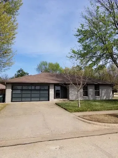 Modern full-view glass garage door on home by Affordable Door Co in Oklahoma City OK